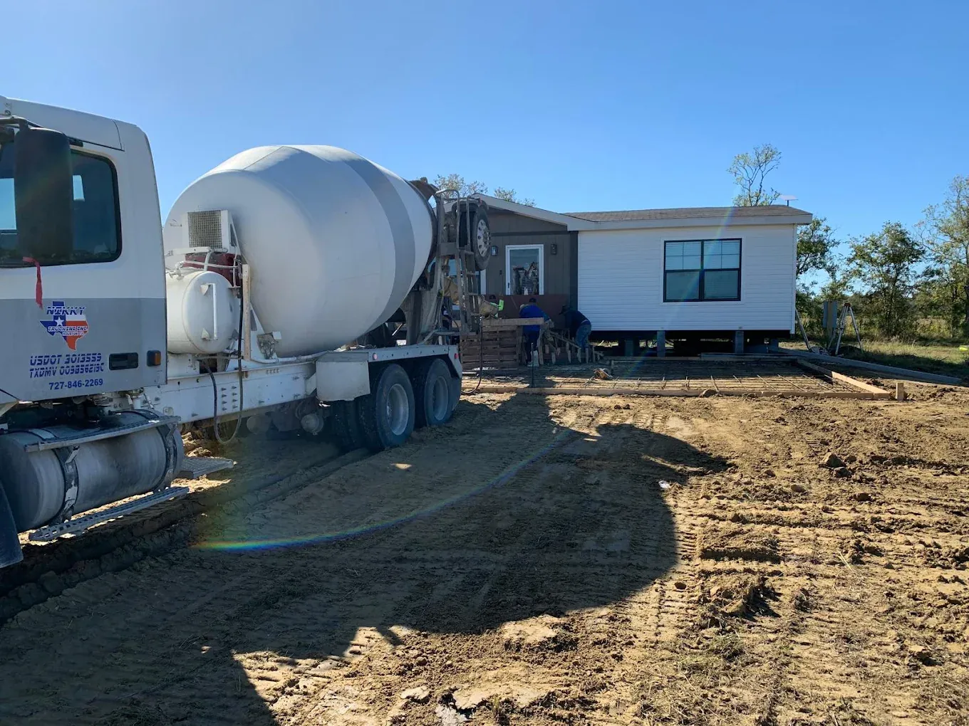 Camión de Nikky Ready Mix Concrete vaciando una losa de cimiento en un sitio residencial del Condado de Montgomery, TX